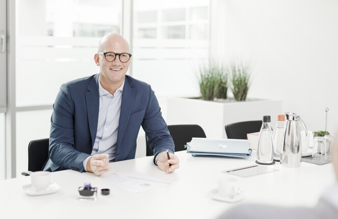 Ein ttpler im Anzug posiert vor der Kamera