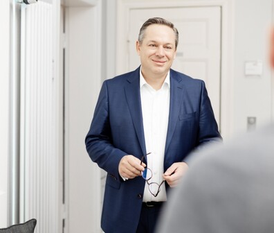 Ein ttpler hält seine Brille in der Hand