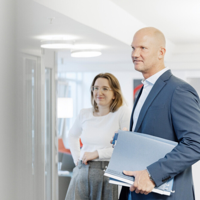 Ein ttpler trägt Ordner unter seinem Arm