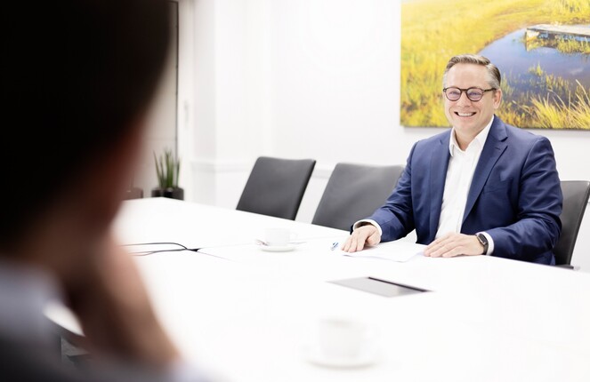 Blick auf einen ttpler welcher an einem weißen Tisch sitzt