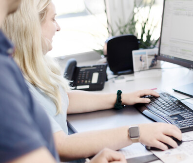 Zwei ttp Mitarbeiter arbeiten zusammen am Computer