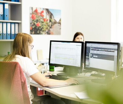 Eine junge ttp Mitarbeiterin arbeitet am PC