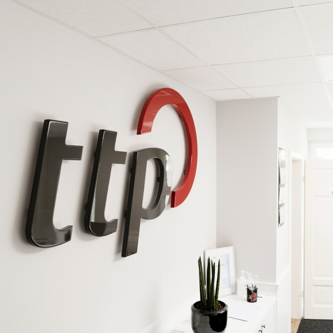 ttp Logo an einer weißen Wand