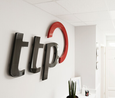 ttp Logo an einer weißen Wand