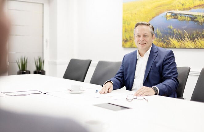 Ein ttpler im Anzug blättert in weißen Papieren