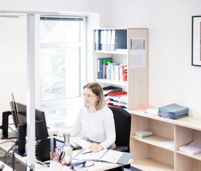 Eine ttplerin sitzt in einem hellen Büro