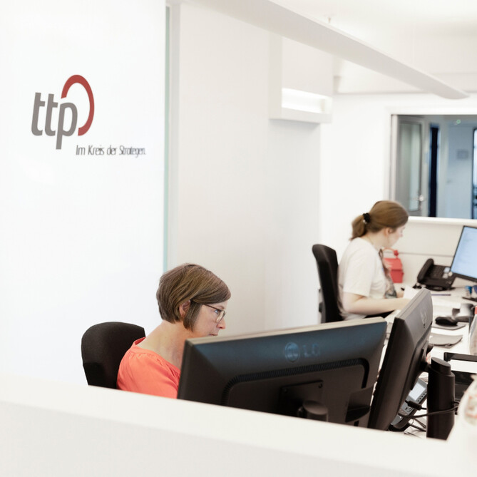 Zwei Frauen sitzen am Empfang des ttp Büros in Flensburg